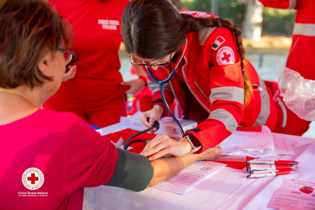 Volontaria della Croce Rossa Italiana misura la pressione arteriosa a una cittadina durante l’attività di prevenzione a Pietralata.